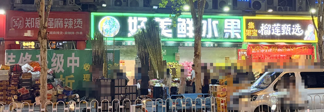 原郑恩强麻辣烫铺位旁,好美鲜水果与榴莲甄选相连;旧麻辣烫门头仍在,门前有升级告示与水果货箱