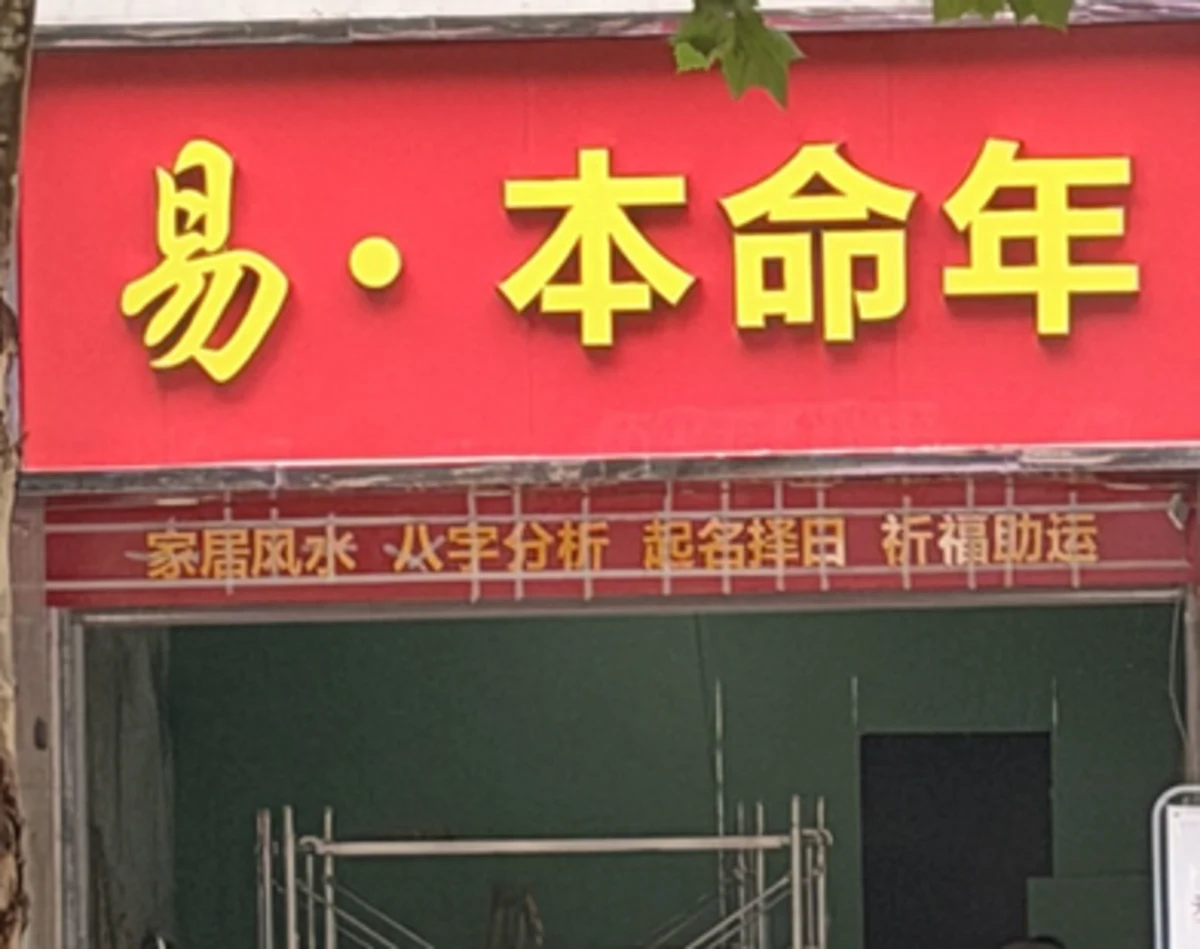 易·本命年新门头,下面列出起名等服务,店内可见脚手架